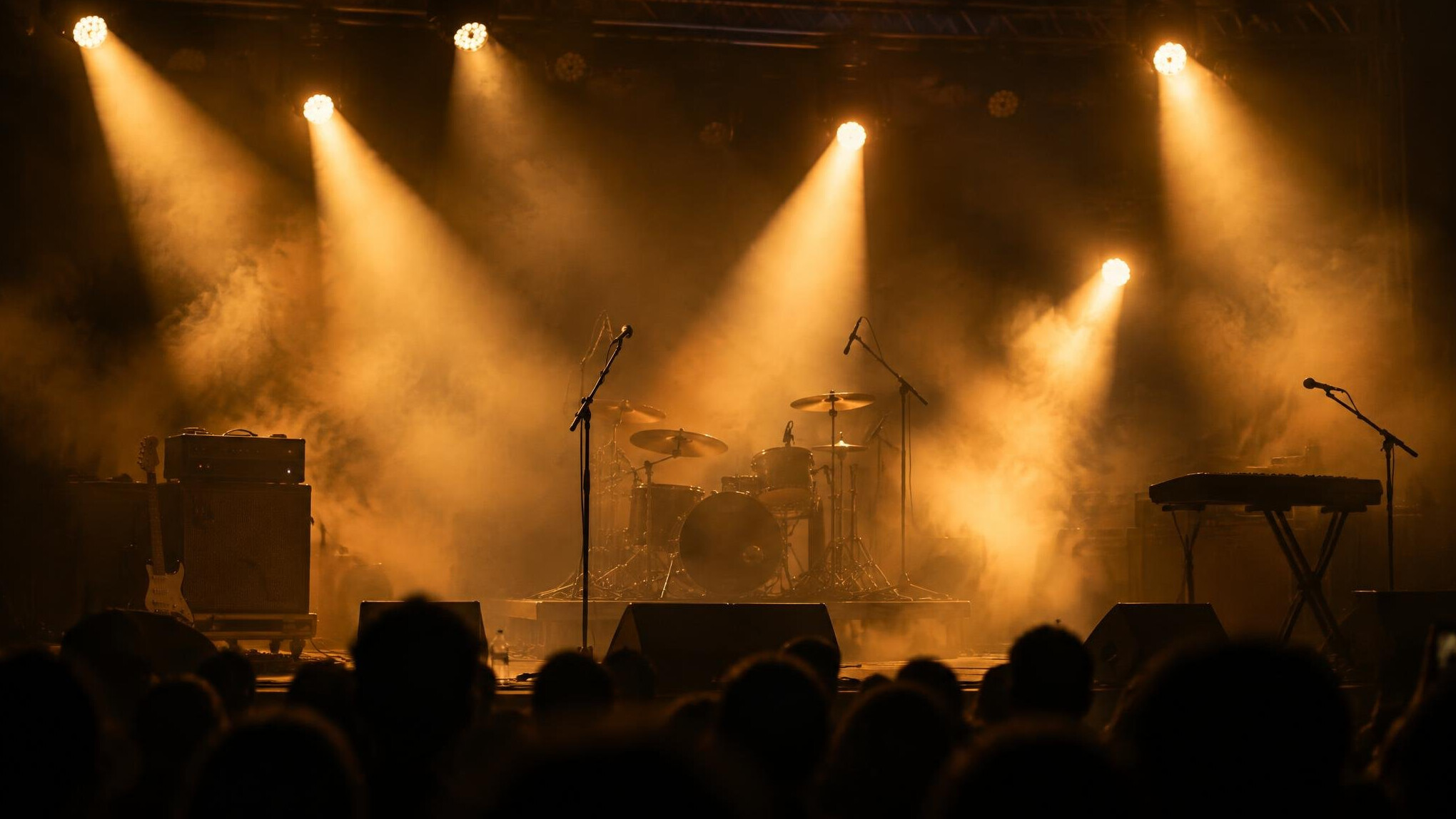 Concert stage lit by warm spotlight beams